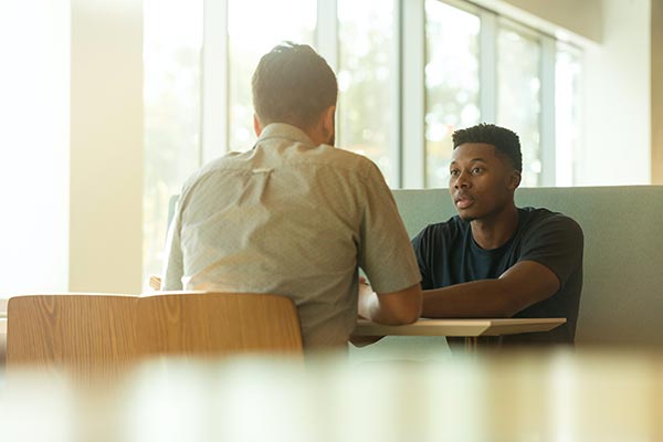 Two colleagues having an open conversation at a table